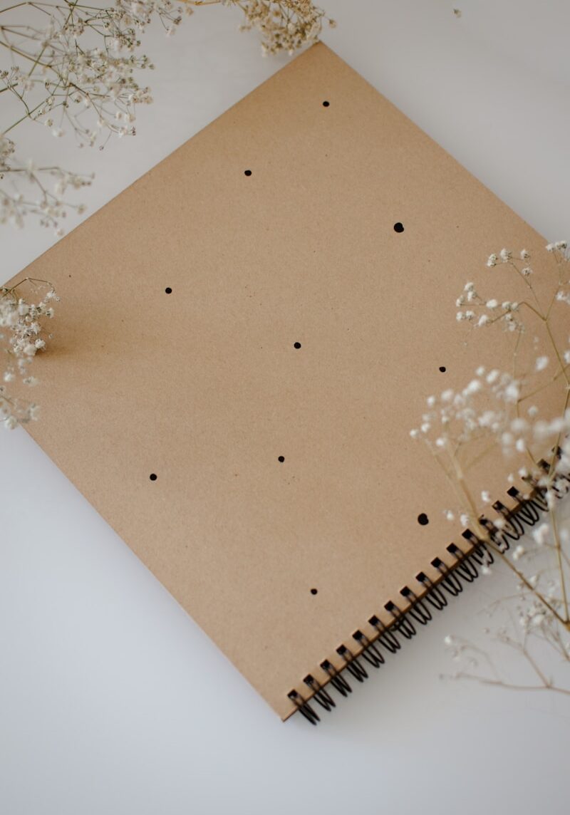 Photo by Evita Tomševica a notebook with a dotted paper cover and flowers